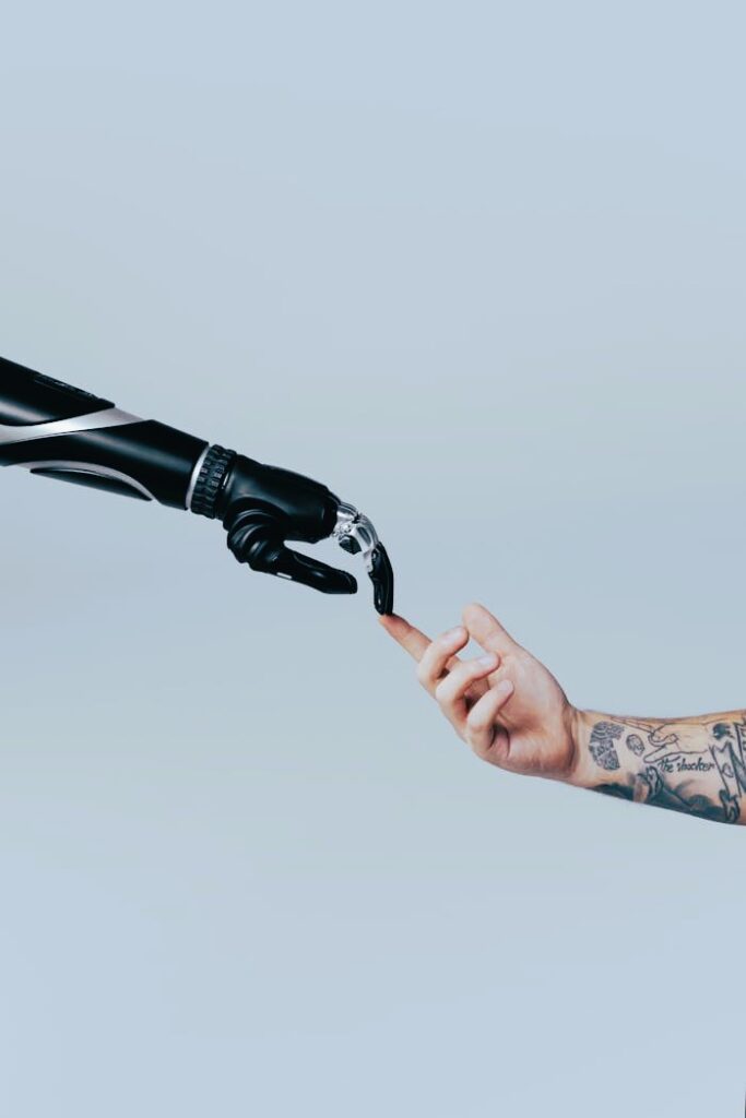 Roboterarm und Menschenarm, die Zeigefingerspitzen berühren sich